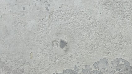 Fototapeta premium Peeling paint on the wall. White peeling paint on the wall. Old concrete wall with cracked flaking paint. The white painted brick wall surface has scratches and peeling paint.