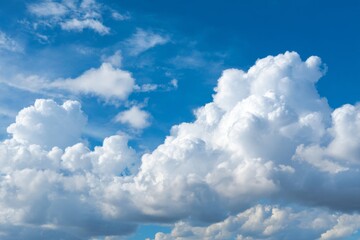 Naklejka premium Puffy white clouds floating in a bright blue sky