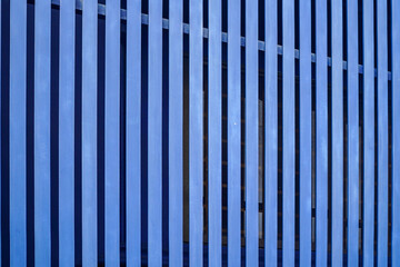 Vertical blue slats create a modern, abstract background. The repeating pattern and color provide...