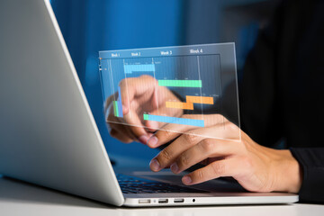Person using laptop with transparent screen displaying project timeline and gantt chart data