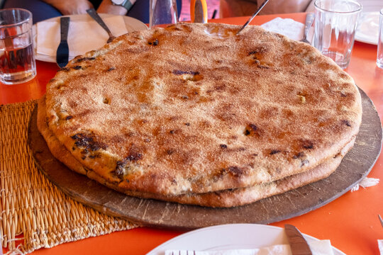 Berber pizza or Medfouna, is a traditional and rustic culinary dish originally from the Morocco. Taken in Rissani Sahara desert, blurred background
