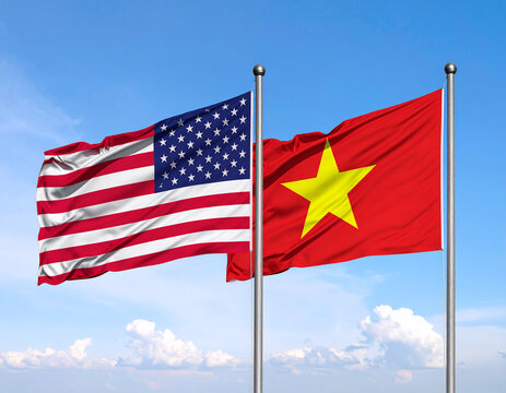the flag of the United States and the flag of Vietnam are displayed high against a blue sky background.
