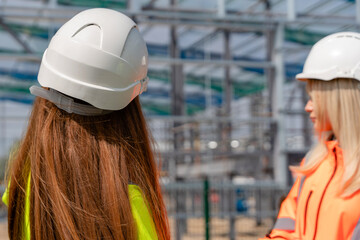 Construction site workers discuss project progress while inspecting steel framework structure