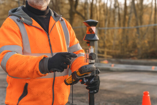 Cloe-up of Surveyor working with equipment at construction site and performing land survey