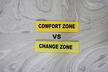 Concept of comfort zone VS change zone write on sticky notes isolated on Wooden Table.