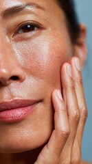 Mature woman gently touching face showing skin texture