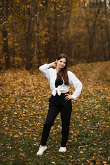 Woman in black jeans in the forest in autumn