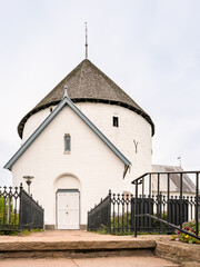 St. Nicolaus Rundkirche in Nylars auf Bornholm, bewölkter Himmel, vertikal
