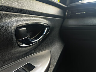 Naklejka premium Inner car door lever for opening the door from inside the vehicle cabin, plastic design with chrome handle.