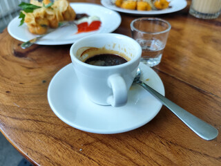 Serve various snacks and drinks on a warm wooden table, in an outdoor cafe. with natural blur.	