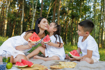 Mother and Children Picnic in Summer Park with Watermelon Kiss and Family Happiness Outdoors