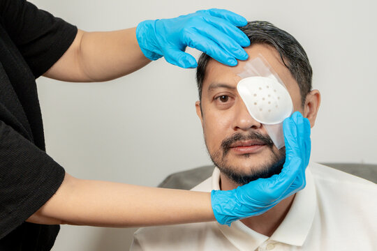 A young man undergoing eye treatment with bandage and eye patch, representing injury care, healing, and medical attention.