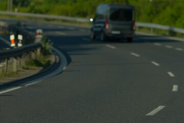 A van and a car are both driving together down a long highway, enjoying the smooth ride along the...