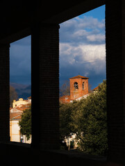 Lucca charming historic center old buildings with clouds seen through city ancient walls porch