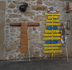 Wooden plaques and signposts showing distances from Viana do Castelo to various destinations along the Caminho de Santiago.