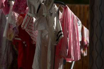 A variety of clothes of different styles and colors are hanging on a clothes line that is stretched...