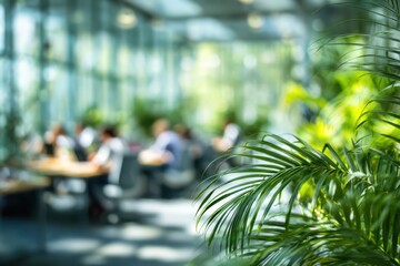 Modern open-plan office with lush green plants, industrial design, and blurred professionals working at desks with computers. Contemporary workspace emphasizing collaboration and natural elements.