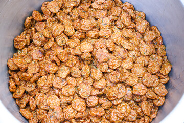 High-angle view of many golden brown fried fish balls arranged in a large stainless steel pot.