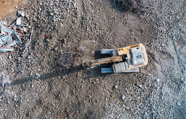 Excavator with hydraulic hammer dismantling a building at a construction site