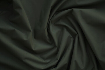 Texture of Dark green military uniform textile cloth with folds