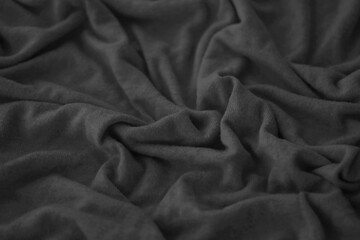 Texture of Dark grey crumpled textile cloth part with small folds