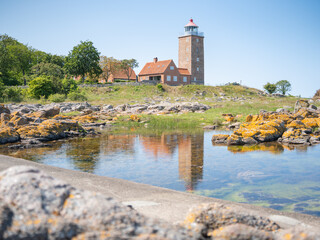 Leuchtturm von Svaneke auf Bornholm, Spiegelung davor im Wasser, horizontal