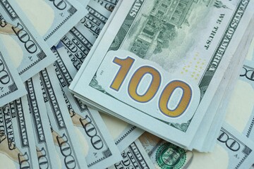 Many hundred dollar bills new banknotes in big pile under the natural light