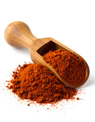 Ground red paprika spilling from wooden scoop on white background
