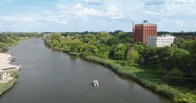 Drone tilt-down of boat on river in Wroclaw, Poland.