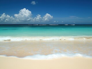 Fototapeta premium Serene beach with turquoise water and white sand: Calm waves on shore under blue sky, fluffy clouds, idyllic tropical paradise for vacation promotions and wallpapers.
