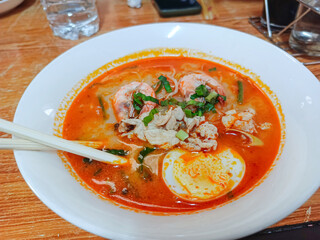 A bowl of spicy seafood noodle soup was put on the table. Delicious and spicy, ready to eat.
