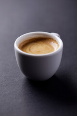 Cup of coffee on paper background. Close up. Copy space.	