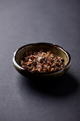 Dry root of Rhodiola rosea. Golden root, rose root. Healthy medical plant on dark paper background. Close up. Copy space.