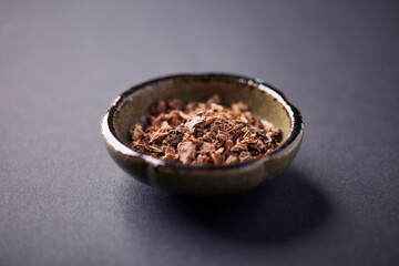 Dry root of Rhodiola rosea. Golden root, rose root. Healthy medical plant on dark paper background. Close up. Copy space.	
