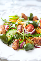 Healthy Salad with Chicken Breast, Cherry Tomatoes, Cucumber, Rocket and Green Olives. Close up.