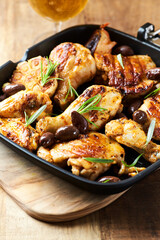 Grilled chicken pieces with kalamata olives and fresh rosemary. Close up.