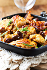 Grilled chicken pieces with kalamata olives and fresh rosemary. Close up.