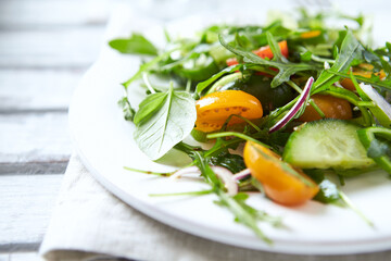 Salad with Tomatoes, Cucumber and Rocket on bright Background. Healthy Snack Idea. Close up.	