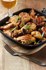 Grilled chicken pieces with kalamata olives and fresh rosemary. Close up.