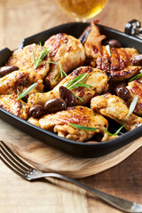 Grilled chicken pieces with kalamata olives and fresh rosemary. Close up.