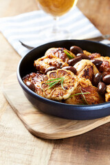 Grilled chicken pieces with kalamata olives and fresh rosemary. Close up.