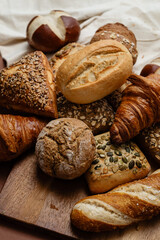 Various types of crusty German breads and flaky pastries offer a delicious spread, perfect for a breakfast or brunch setting