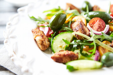 Healthy Salad with Chicken Breast, Cherry Tomatoes, Cucumber, Rocket and Green Olives. Close up.
