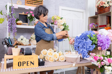 Small business, florist senior woman lifestyle arranging bouquet in flower shop, elderly entrepreneur working with passion handmade floral design, Asian silver hair female  happy working retirement