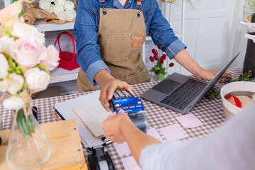 Florist small business senior woman lifestyle holding credit card and laptop, florist Asian female presenting contactless payment, confident silver-age retail owner modern aging people with technology