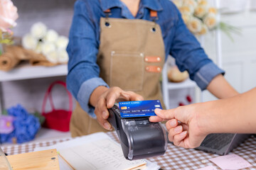 Asian senior woman, small business lifestyle florist shop accepts credit card payment cashless, smile elderly flower entrepreneur handling retail transaction, modern aging people with technology