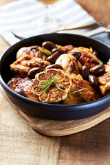 Grilled chicken pieces with kalamata olives and fresh rosemary. Close up.
