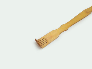 A wooden back scratcher on a white background, a hand shaped itch relief tool with long handle