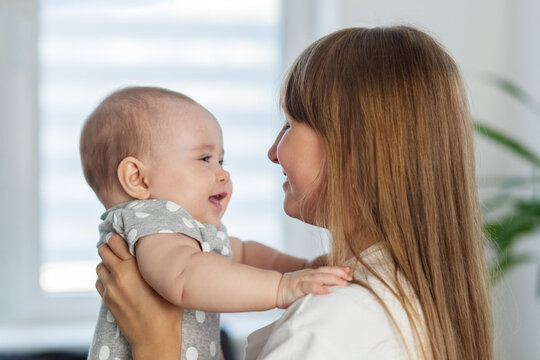 Sister smiling at baby in sweet close moment.