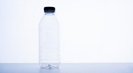 Fototapeta premium Clear plastic water bottle with black cap against a white background